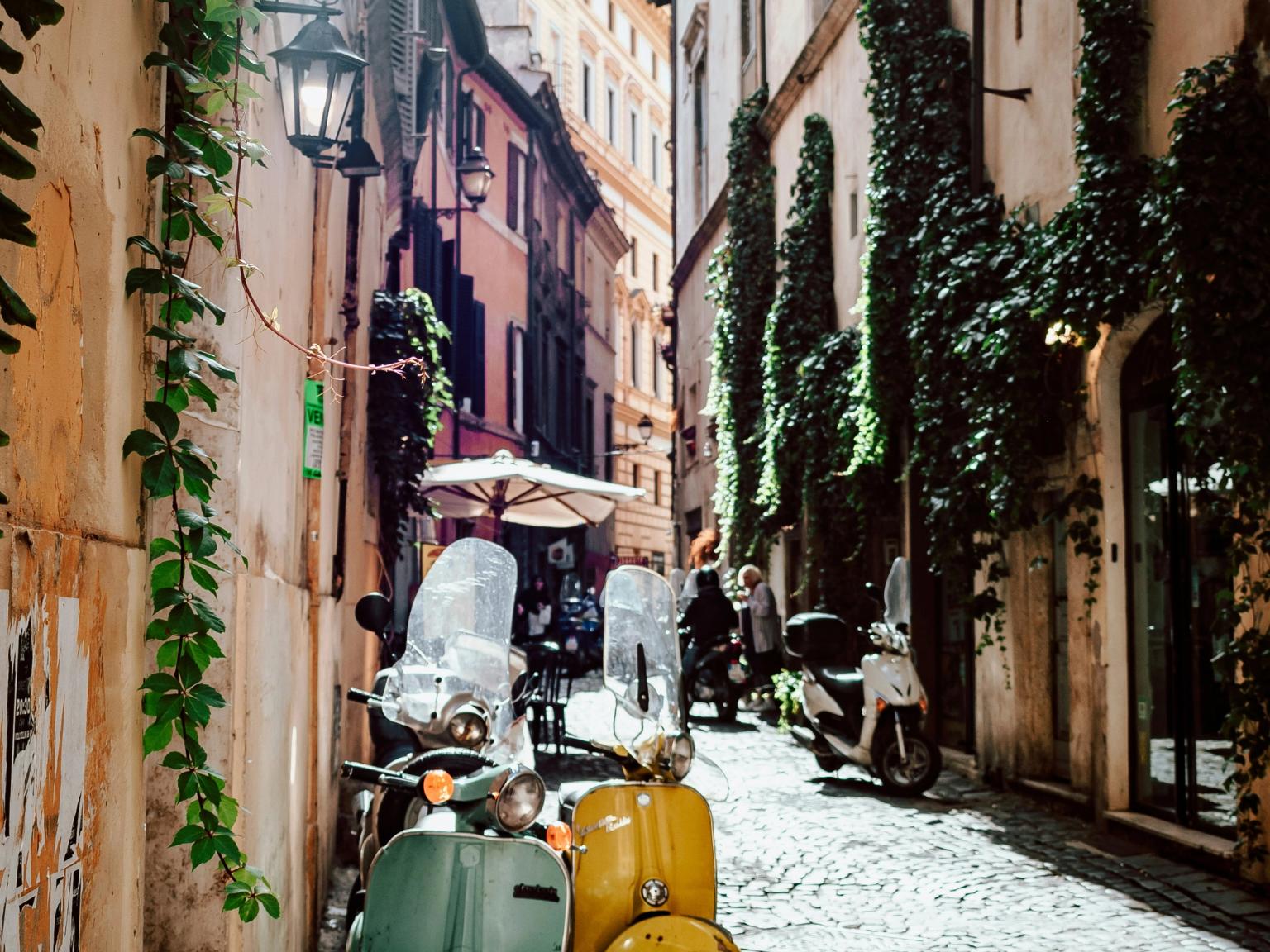 grønne og gule scootere parkert på en brosteinsbelagt gate