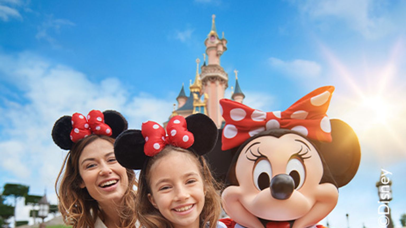 en kvinna och två barn tar en selfie med minnie mouse framför ett slott