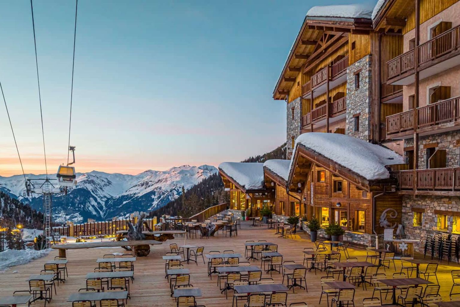 een groot gebouw met veel tafels en stoelen ervoor, Hôtel Le Carlina door Les Etincelles, Les Arcs