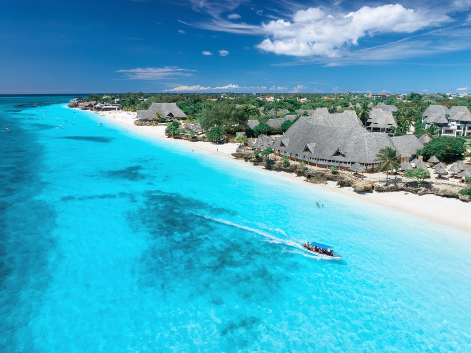 en flygvy av en tropisk strand med en båt i vattnet, Nungwi, Zanzibar