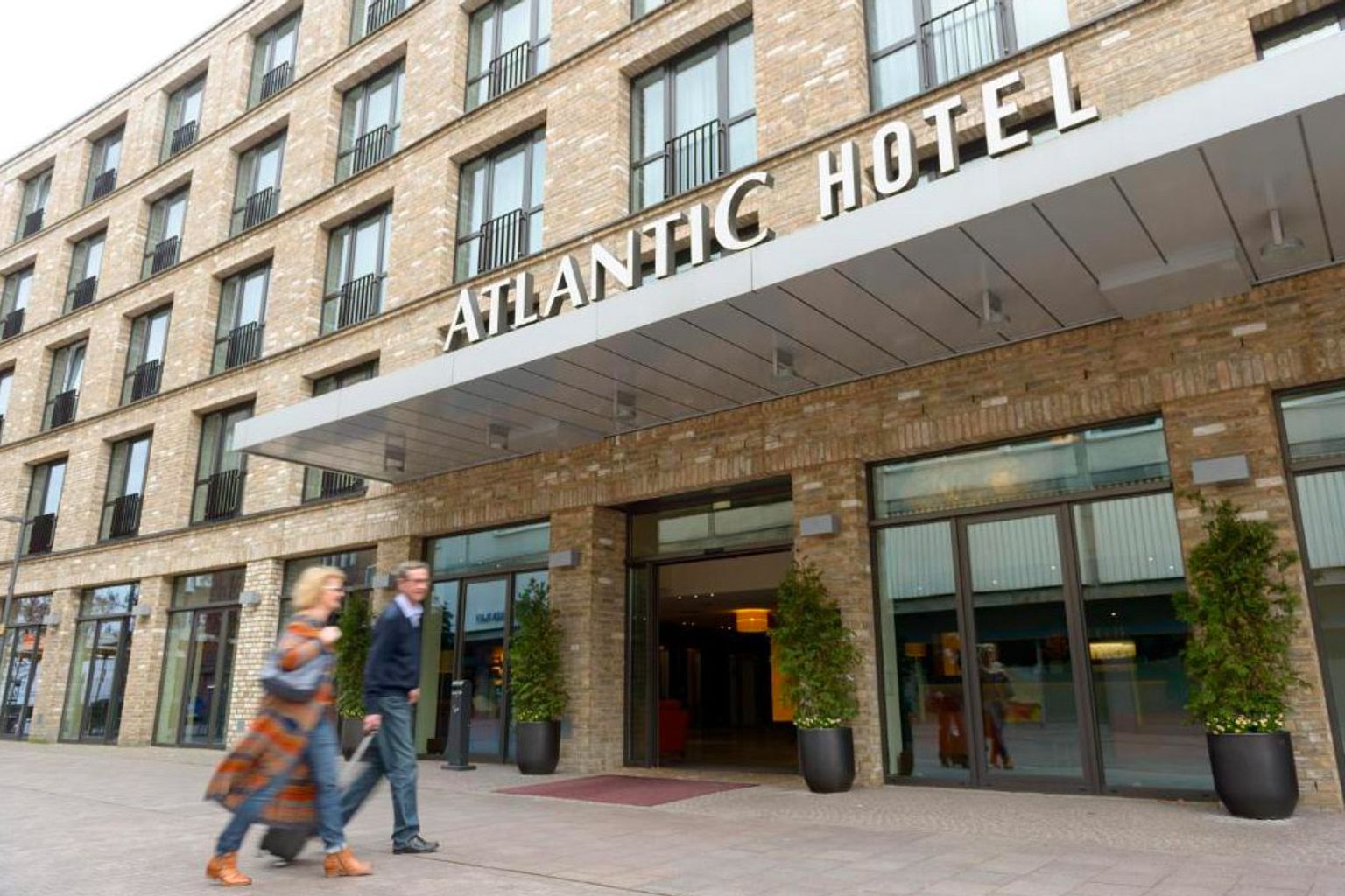 en man och en kvinna går framför atlantic hotel