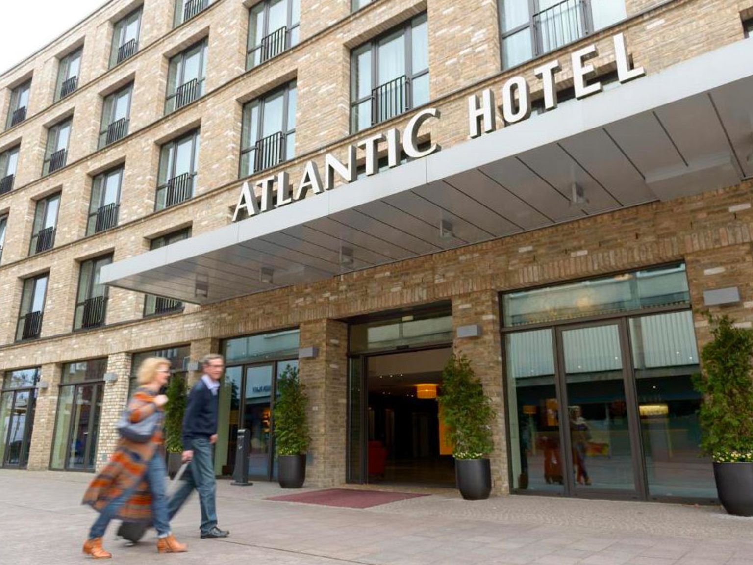 en man och en kvinna går framför atlantic hotel