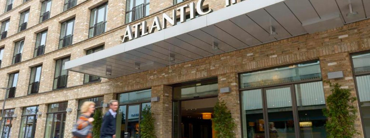 en man och en kvinna går framför atlantic hotel