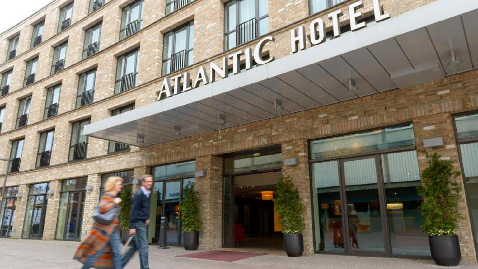 en man och en kvinna går framför atlantic hotel