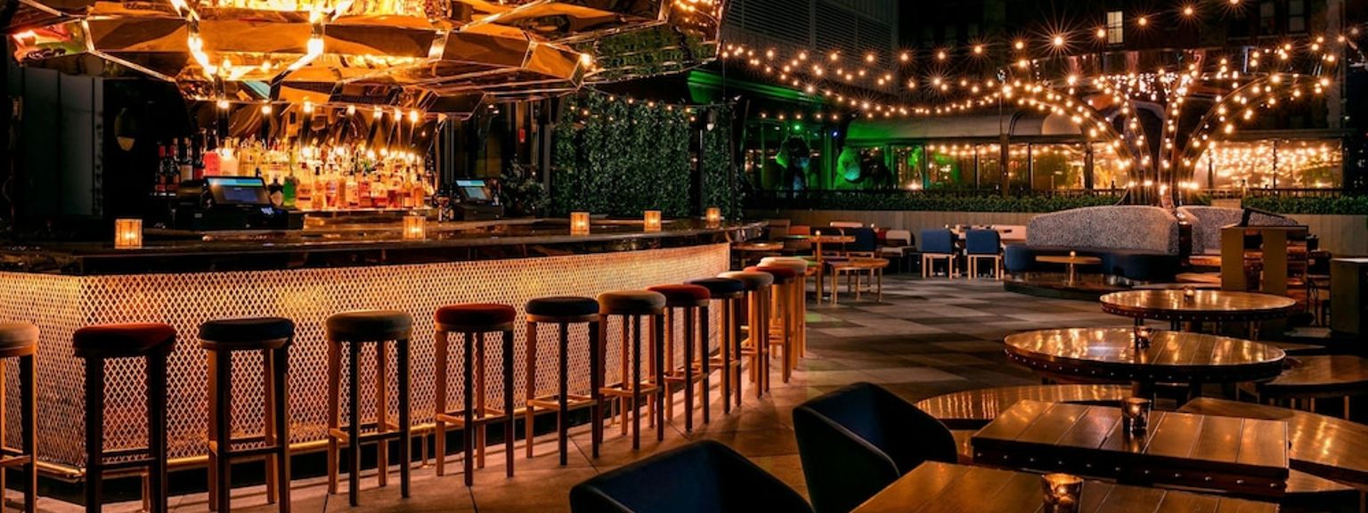 en restaurant med bord og stoler og en bar om natten