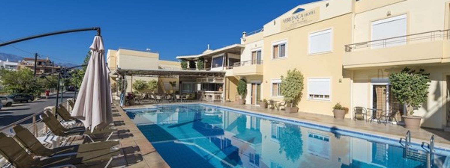 en stor simbassÀng omgiven av stolar och paraplyer framför ett hotell