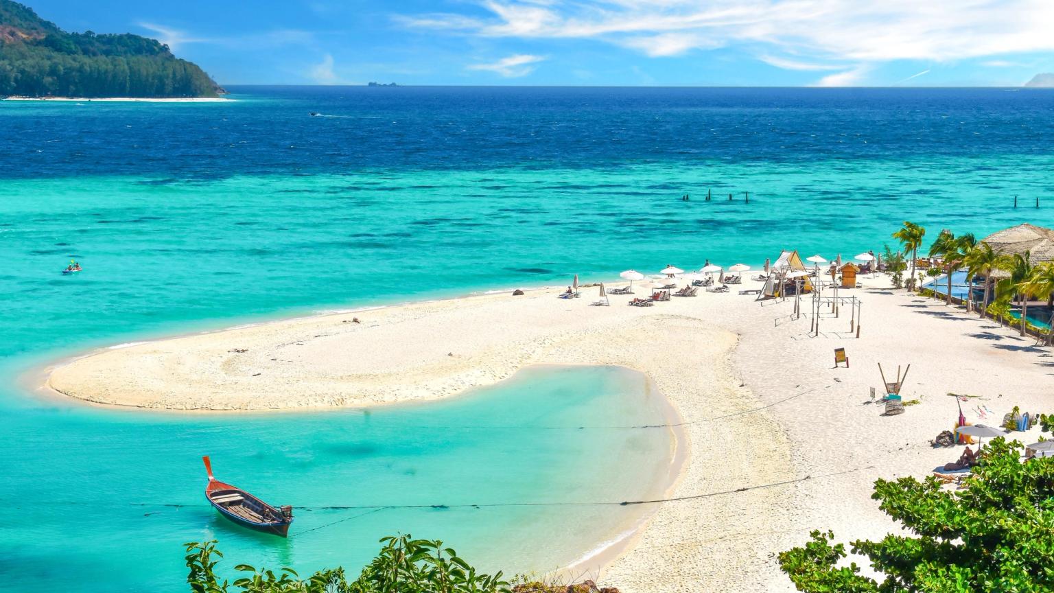 ein Boot schwimmt auf einer kleinen Insel mitten an einem tropischen Strand