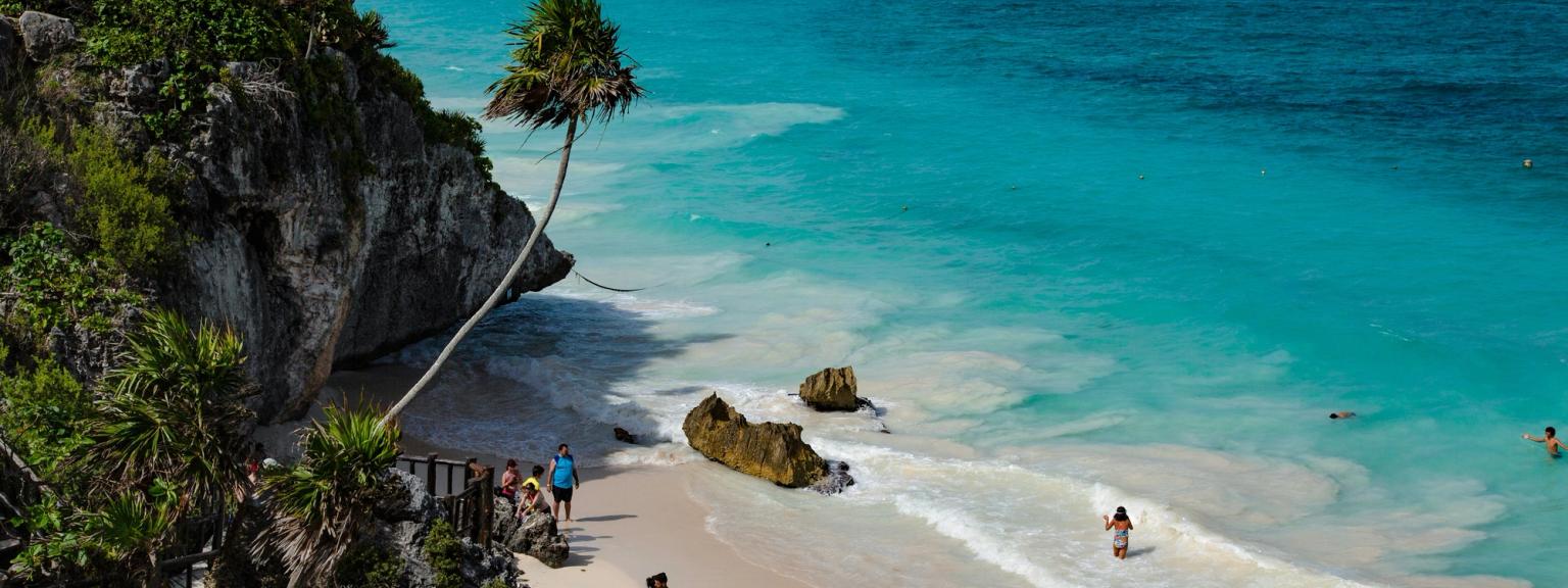 en gruppe mennesker står på en strand nær havet