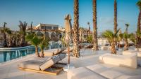 Zonnig resortzwembad met palmbomen, moderne ligstoelen en hotelgebouwen. Stella Blue Seaside Resort