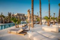 Zonnig resortzwembad met palmbomen, moderne ligstoelen en hotelgebouwen. Stella Blue Seaside Resort