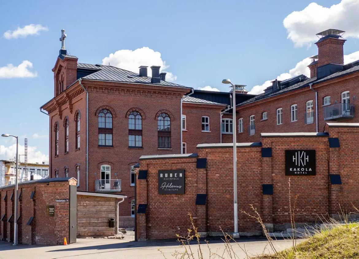 Et rødt murstensbygningskompleks med skilte for Kakola Hotel og Ruben Ristorante.