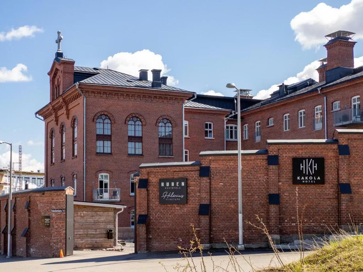 Et rødt murstensbygningskompleks med skilte for Kakola Hotel og Ruben Ristorante.