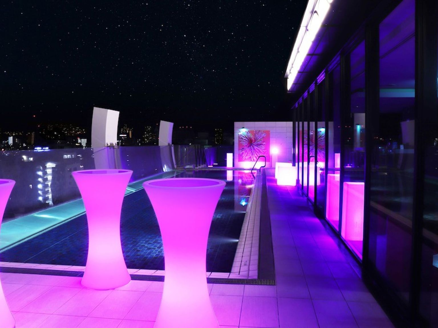 et svømmebasseng er opplyst med lilla lys om natten