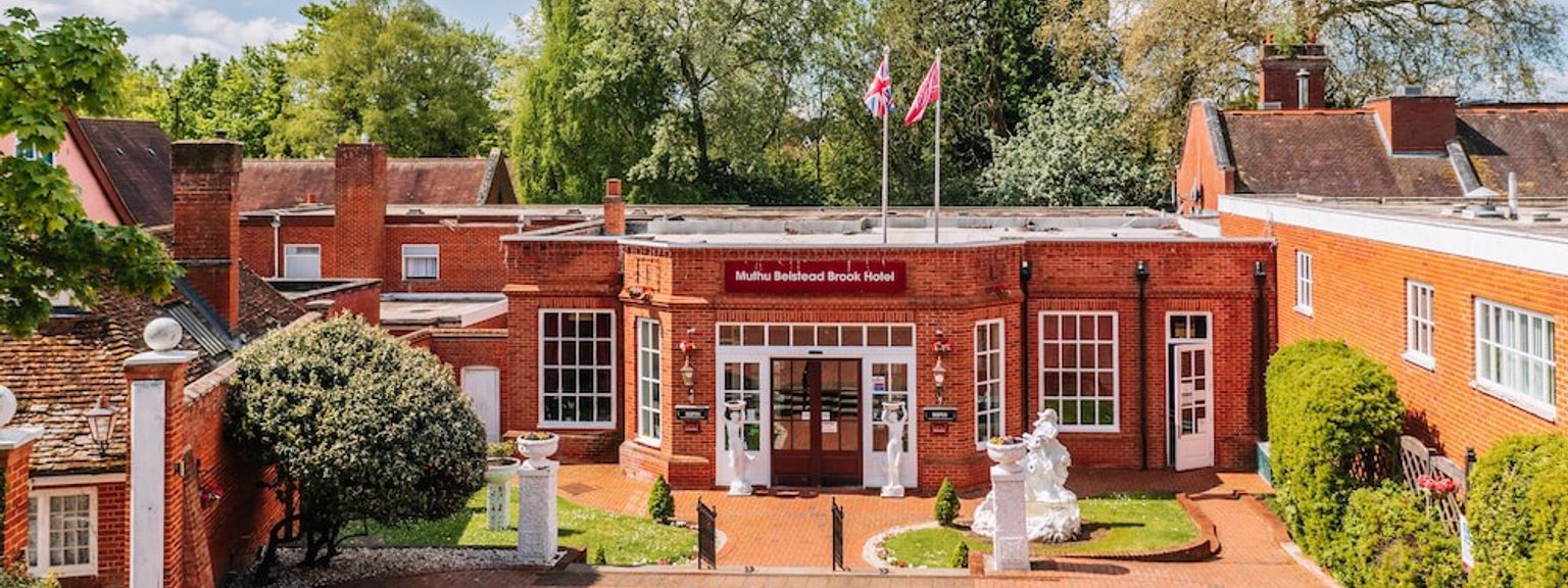 en stor rød murbygning med en murvei som fører til den