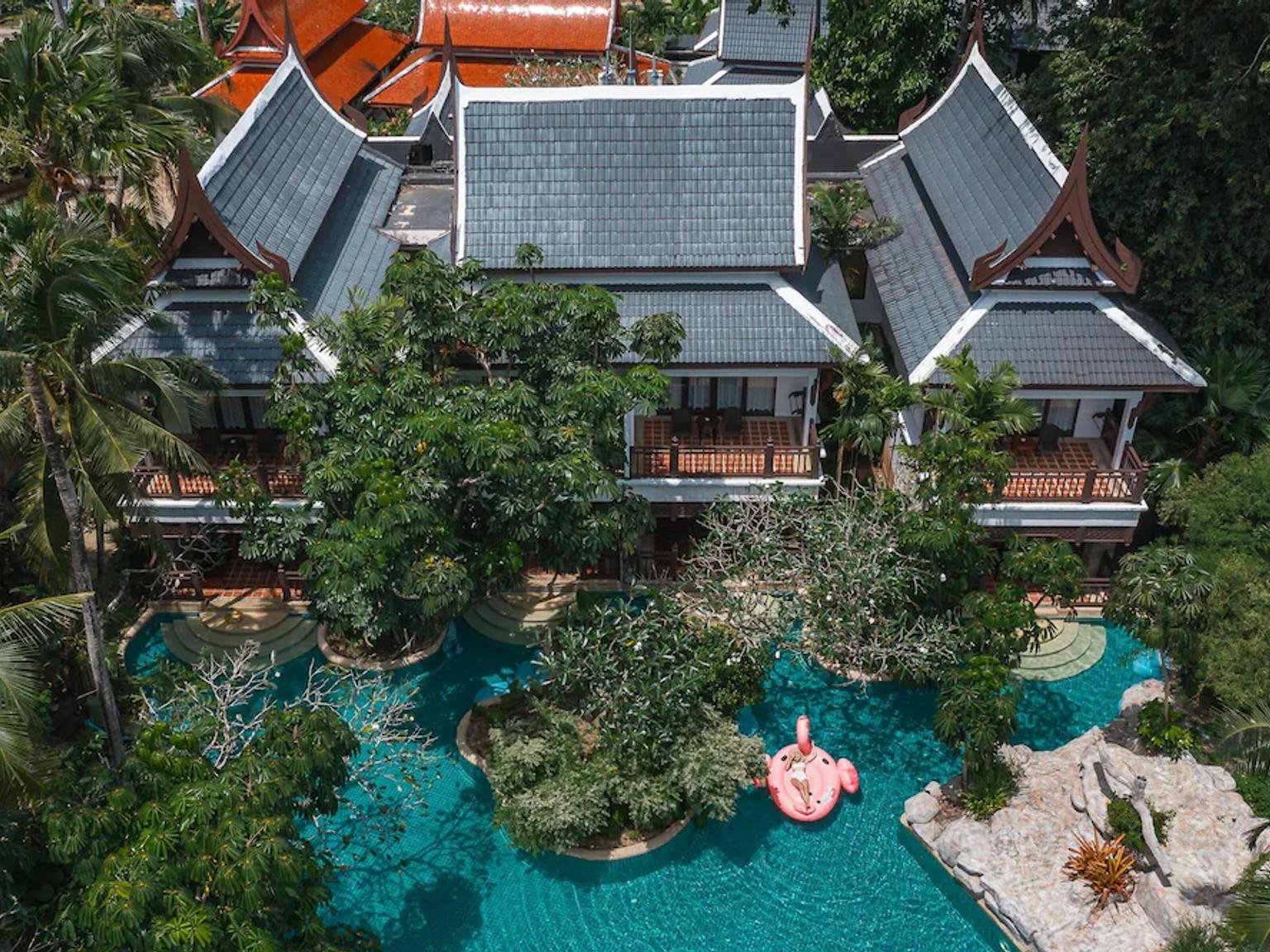 en flygvy av en stor swimmingpool omgiven av träd och byggnader