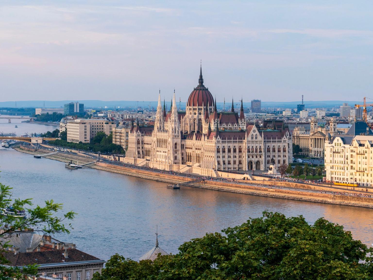 et luftfoto av parlamentsbygningen i Budapest med en elv i forgrunnen.