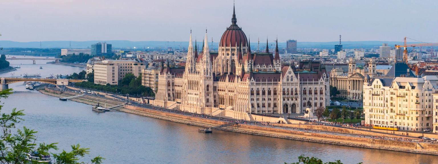 et luftfoto av parlamentsbygningen i Budapest med en elv i forgrunnen.