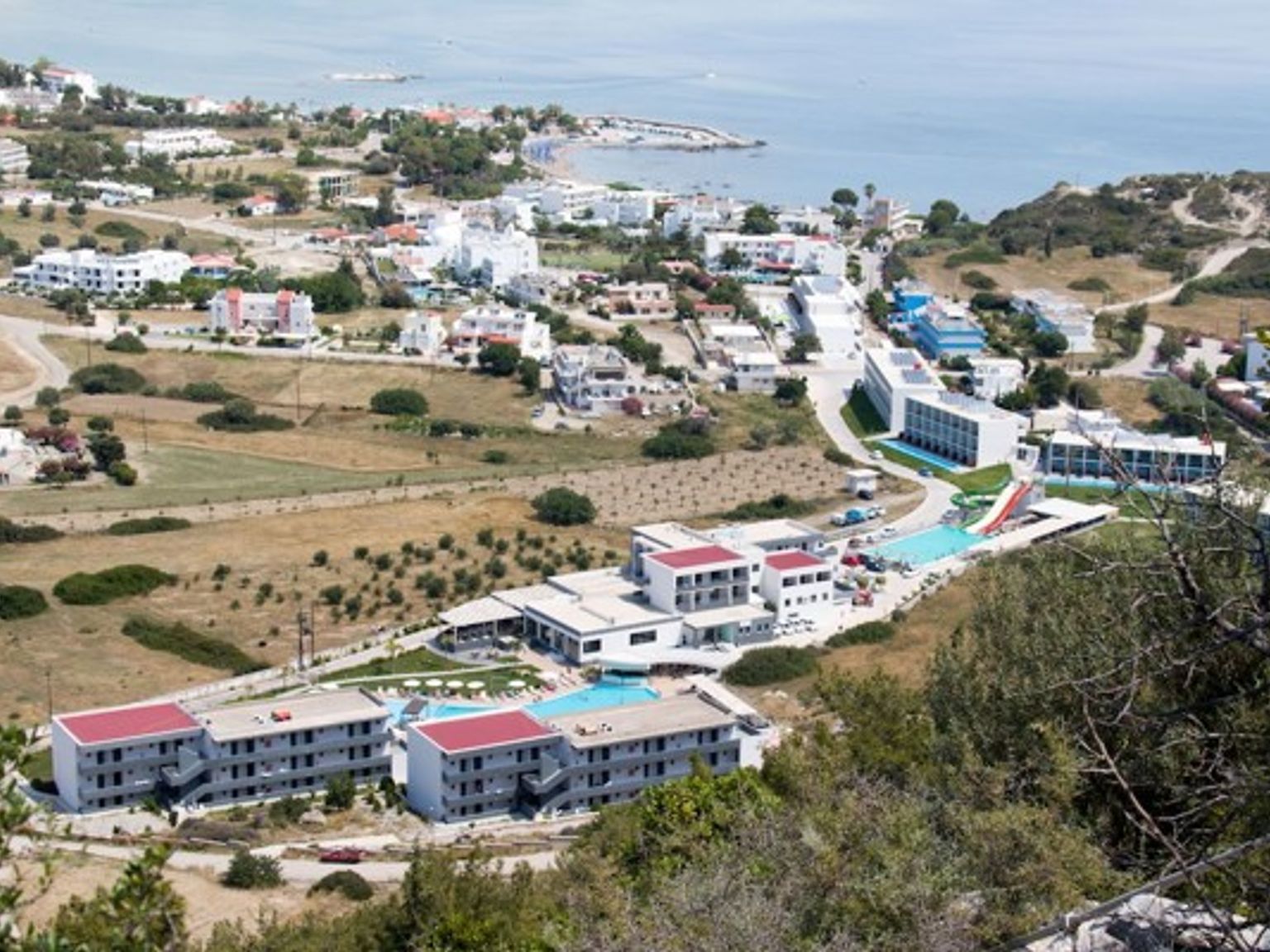 en luftvisning af et resort på en bakke med udsigt over havet