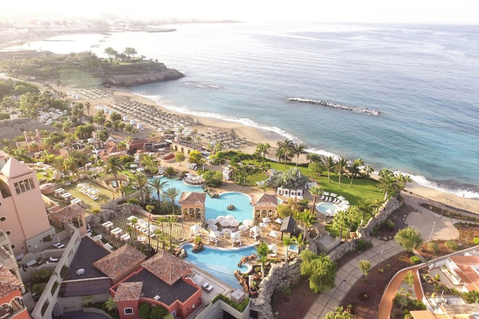 en flygvy över en tropisk resort med en swimmingpool och en strand