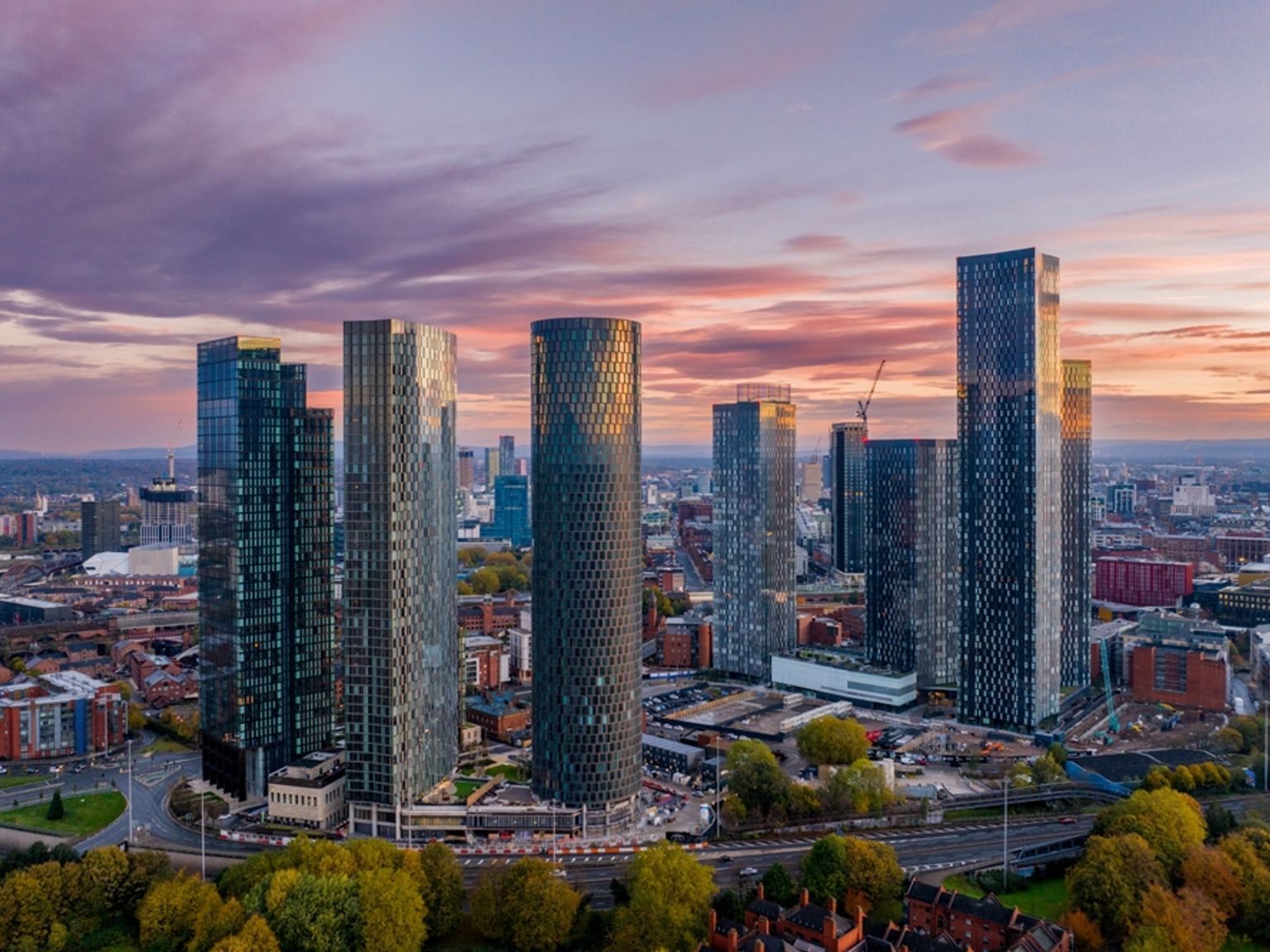 an aerial view of a city skyline with tall buildings at sunset.