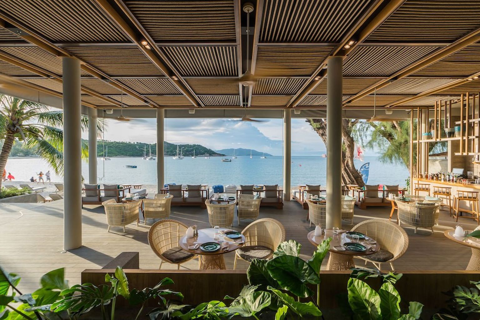 en restaurang med bord och stolar med utsikt över havet