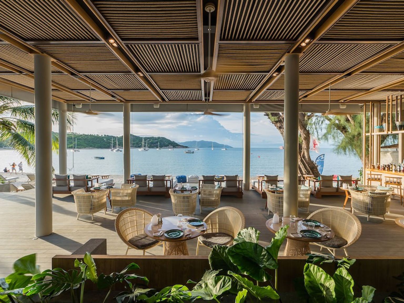 ein Restaurant mit Tischen und Stühlen mit Blick auf den Ozean