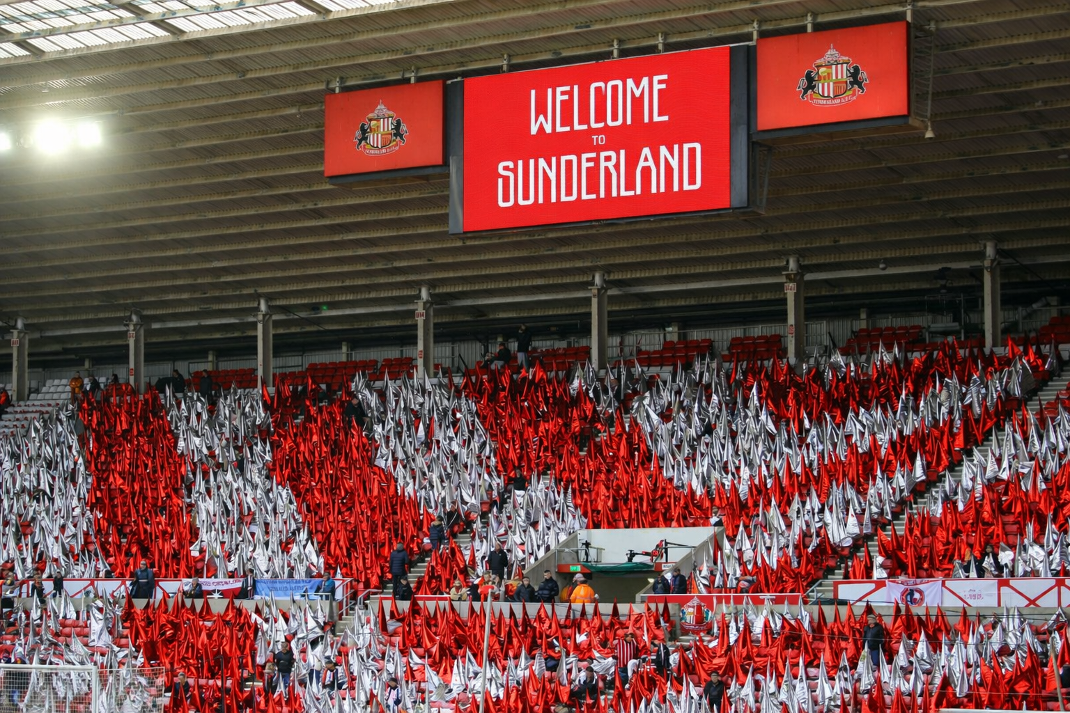 Red and white flags fill the stadium stands, with screens above reading "WELCOME TO SUNDERLAND."