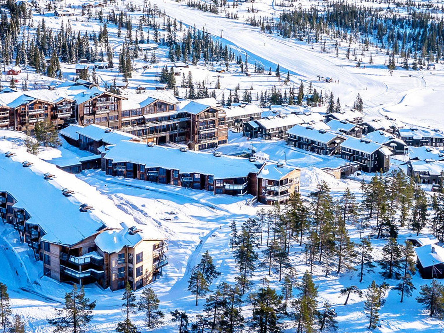 et luftfoto av et skianlegg dekket av snø