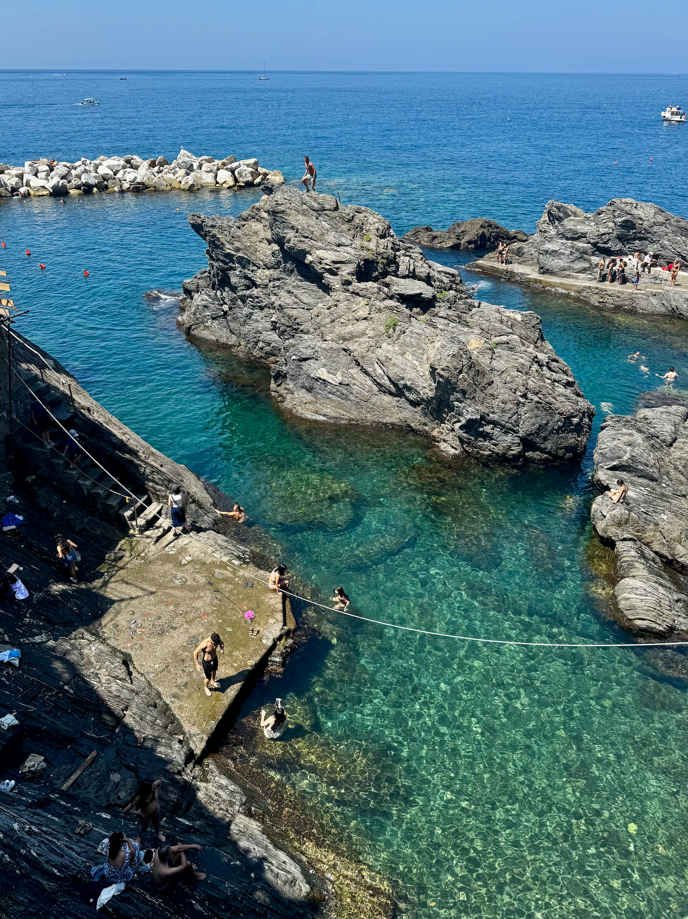 en grupp människor simmar i en stenig vattenmassa