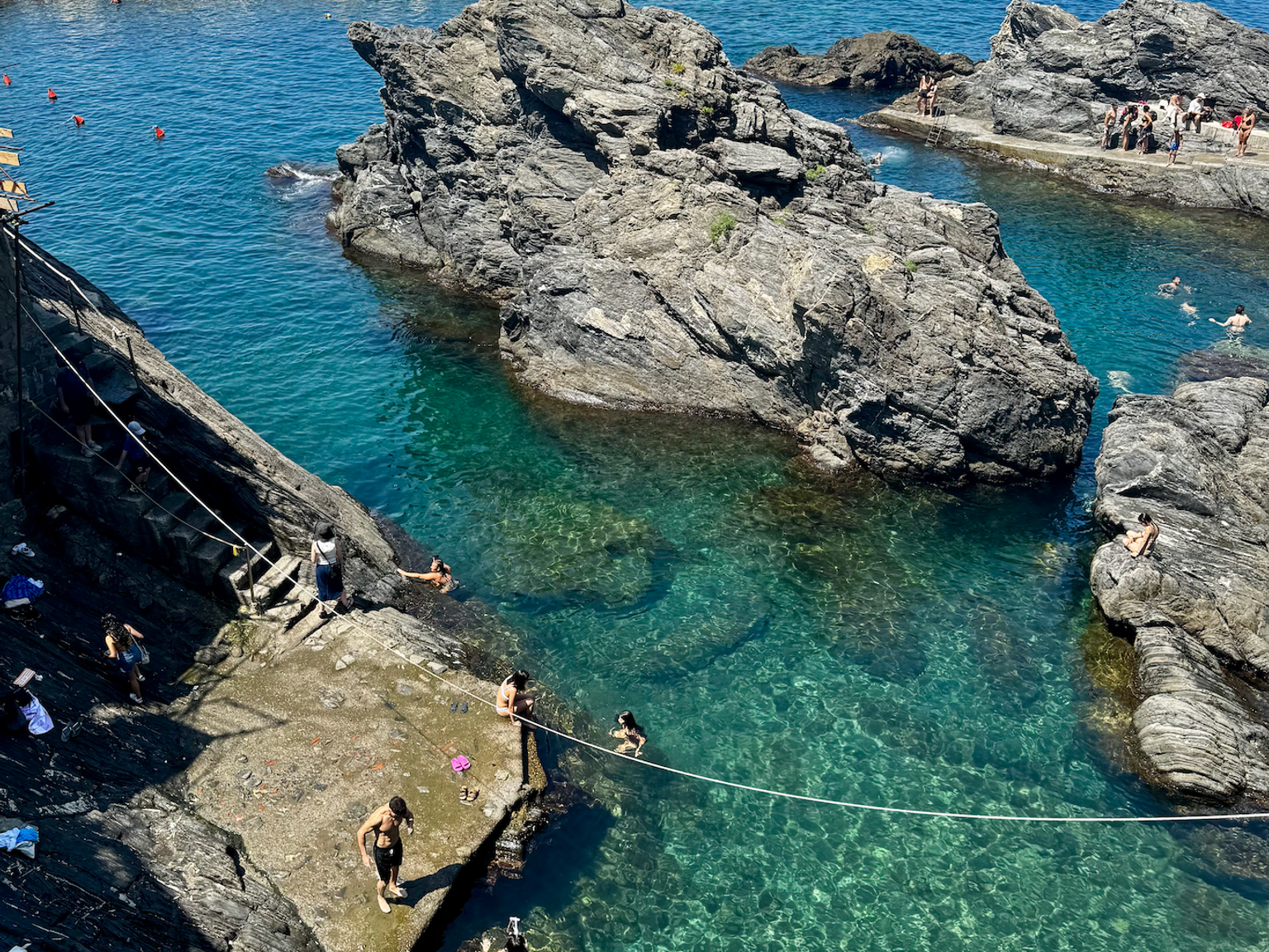 en grupp människor simmar i en stenig vattenmassa