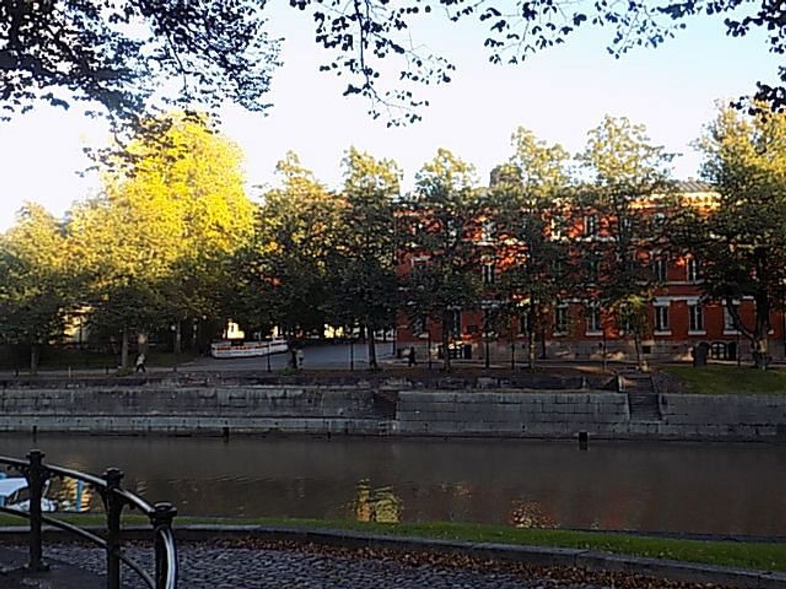 a bridge over a river with a large building in the background