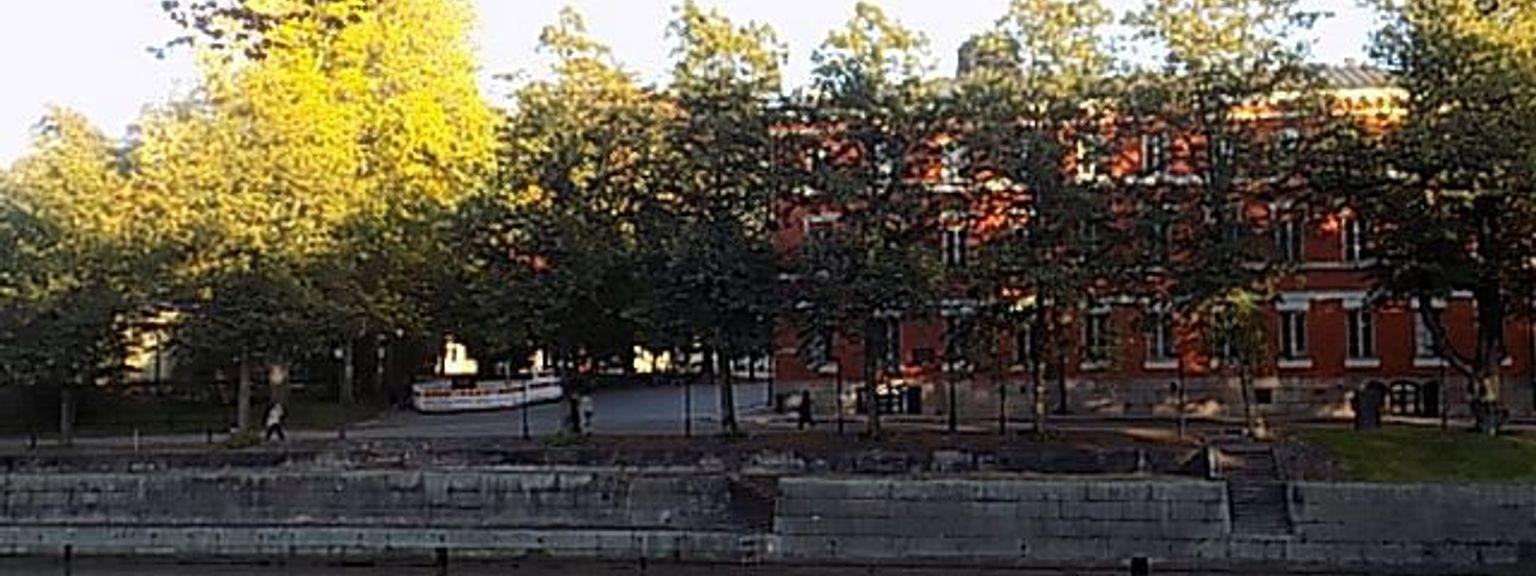 a bridge over a river with a large building in the background