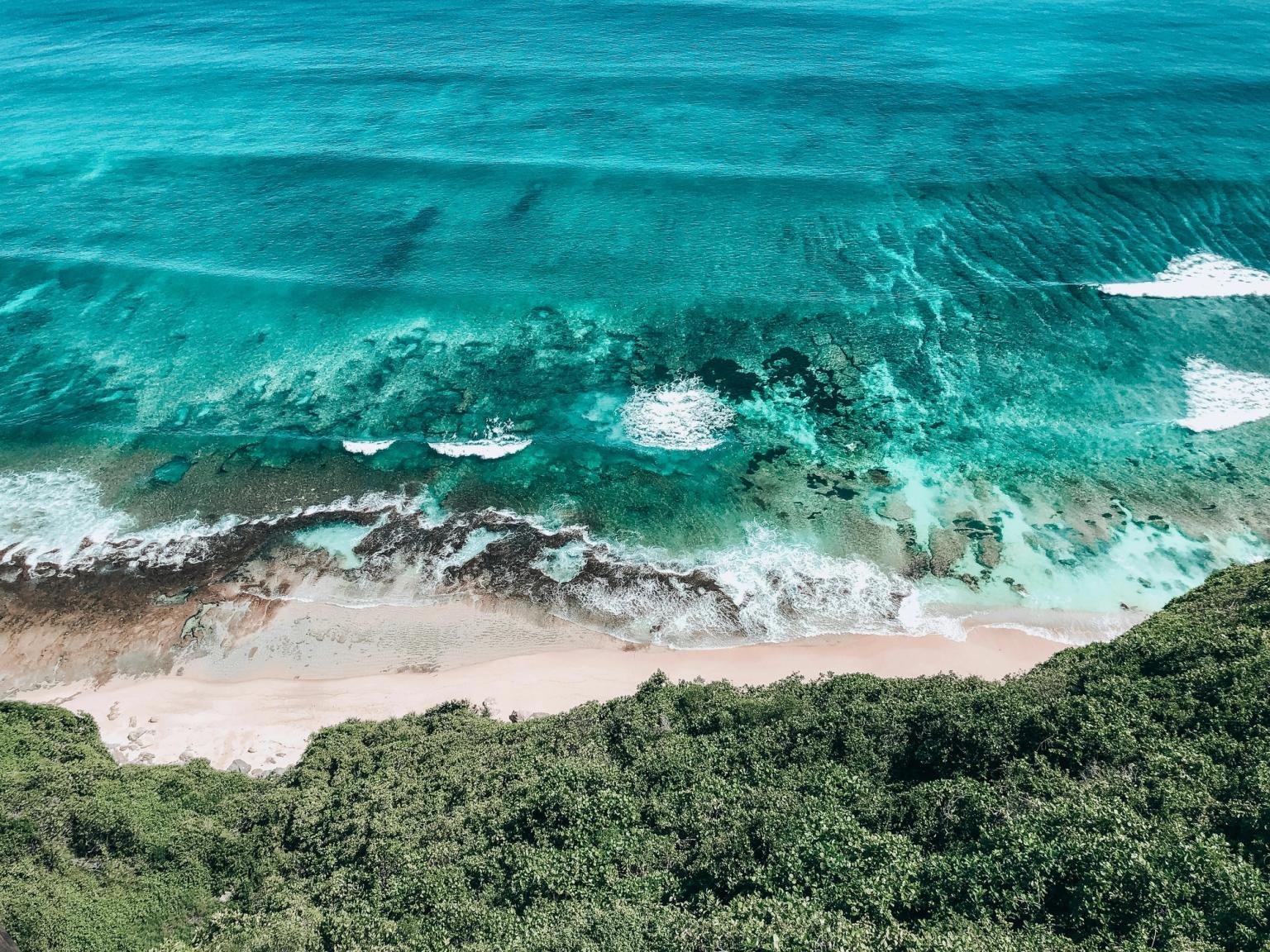 en flygvy över en strand med vÄgor som kraschar pÄ stranden