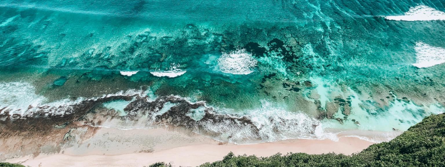 en flygvy över en strand med vÄgor som kraschar pÄ stranden
