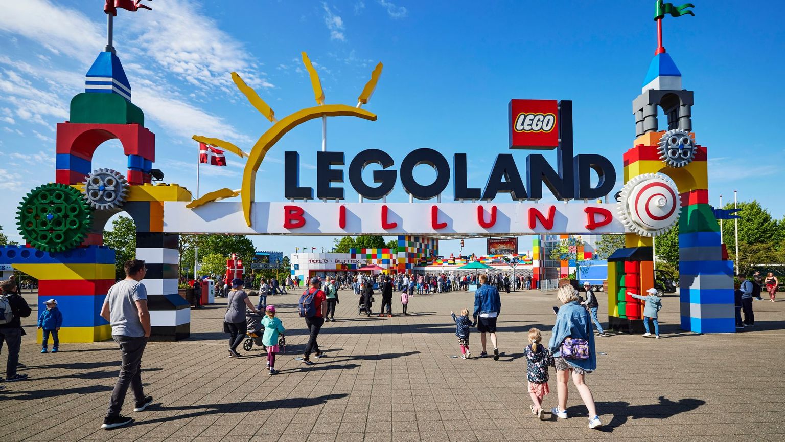 en grupp människor går under en skylt som säger legoland billund.