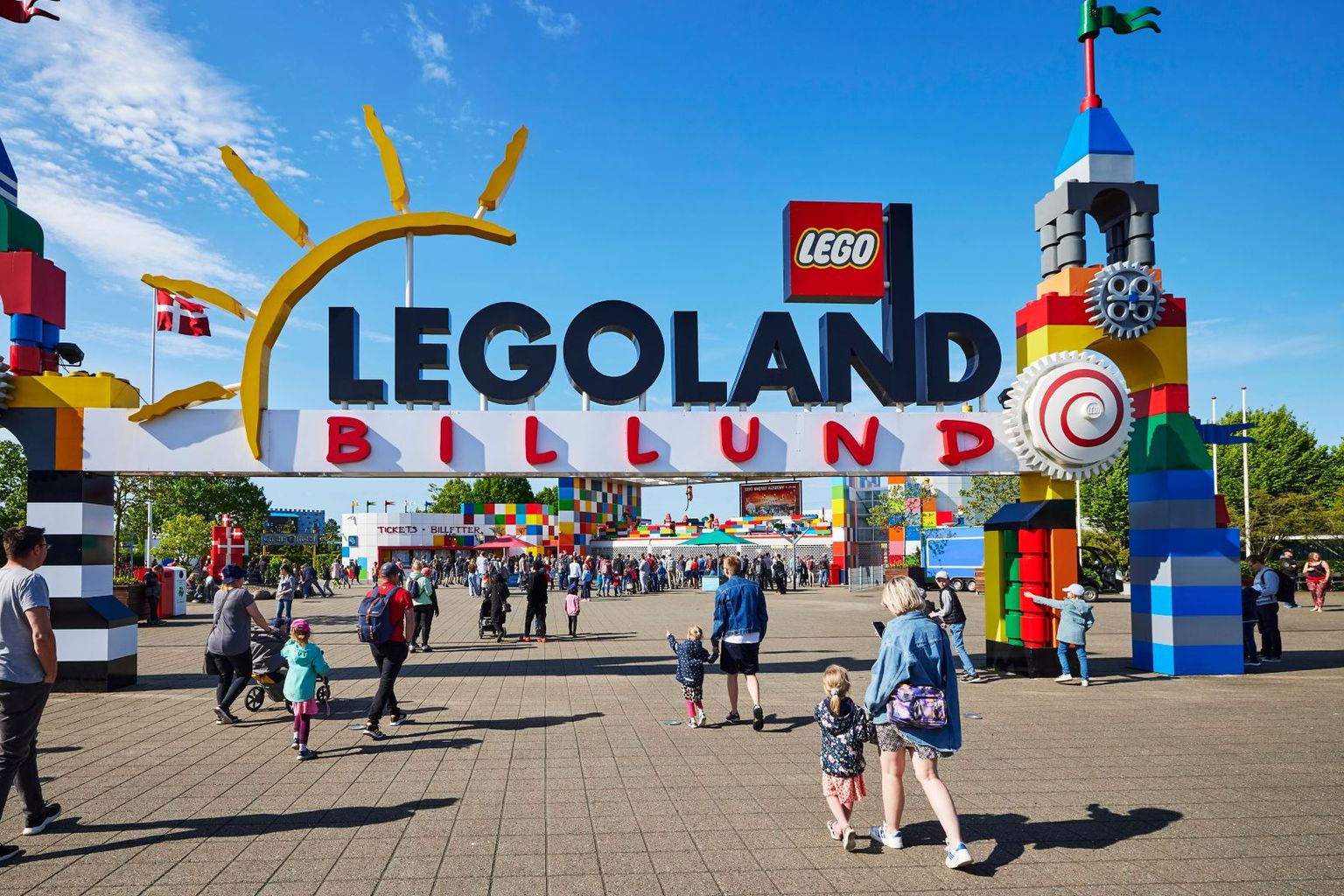 en grupp människor går under en skylt som säger legoland billund.