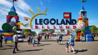 en gruppe mennesker går under et skilt som sier legoland billund.