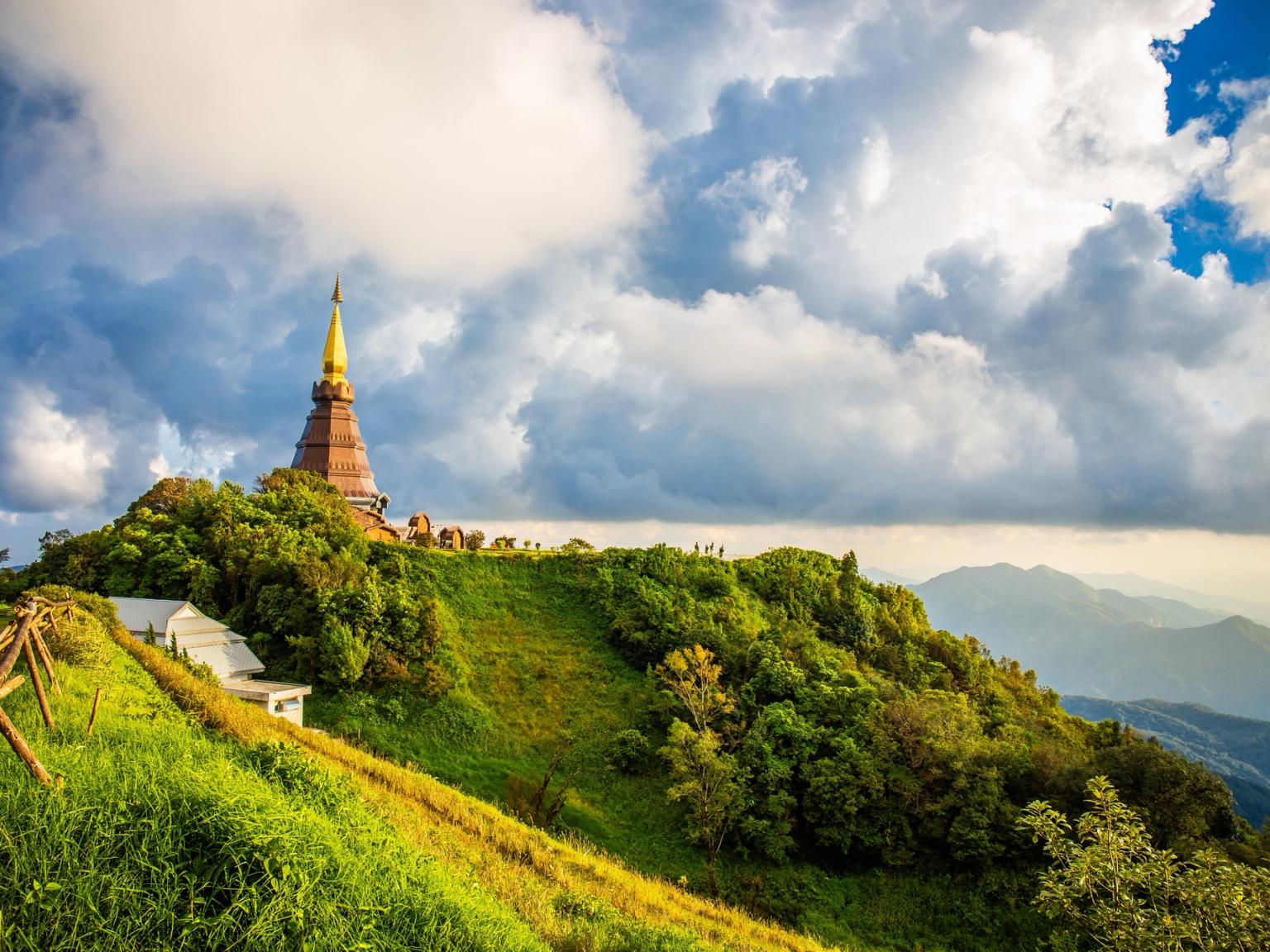 en pagod sitter på toppen av en kulle omgiven av träd i Chiang Mai, Thailand