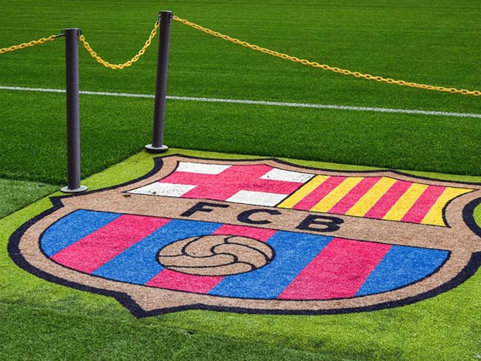 fc barcelona-logoen er malt på gresset på en fotballbane.