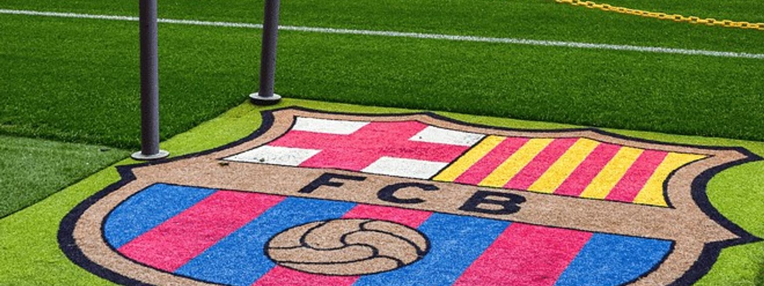 fc barcelona-logoen er malt på gresset på en fotballbane.
