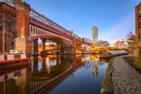 a bridge over a river with a building in the background at night