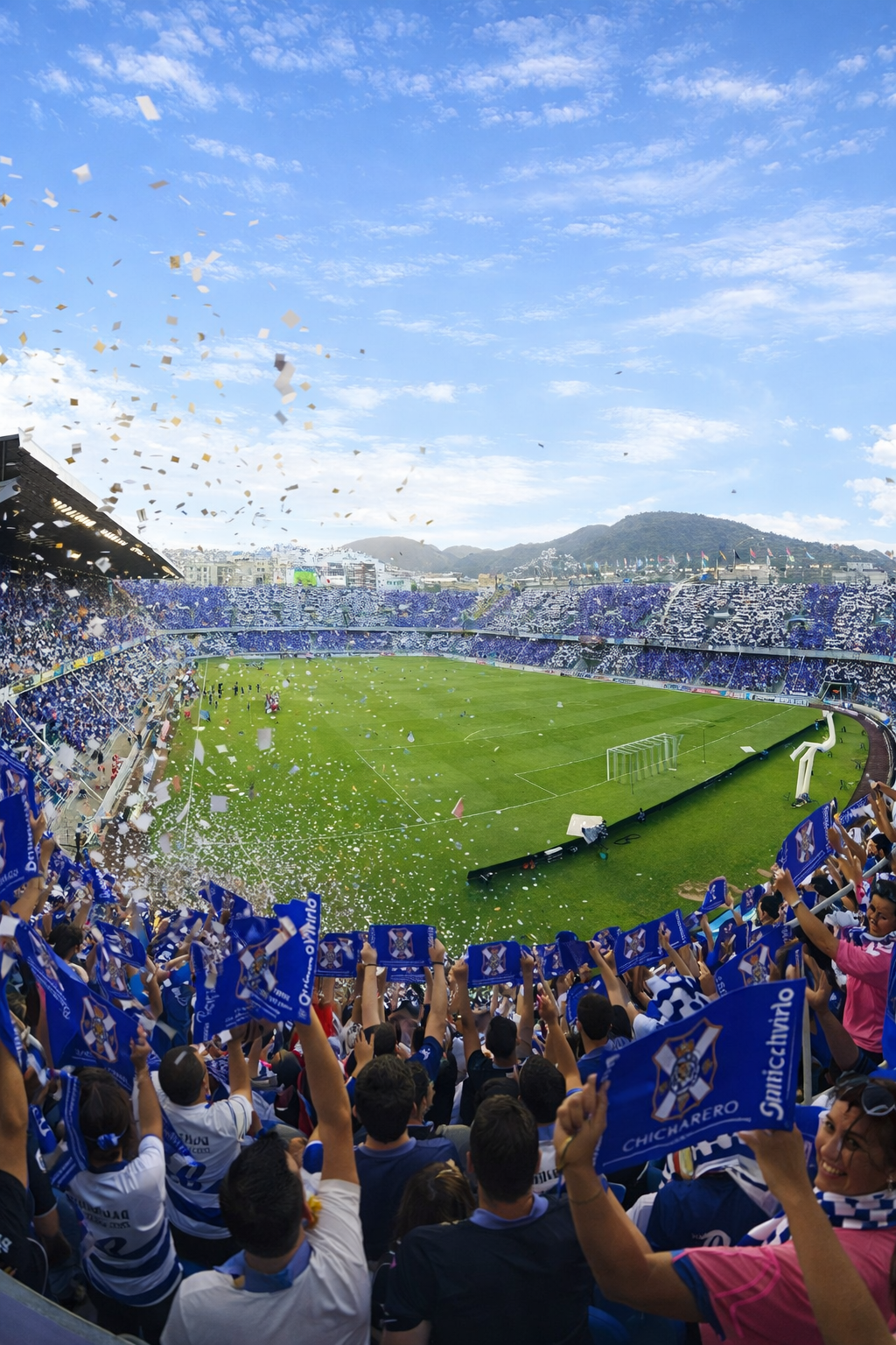 Een levendig voetbalstadion gevuld met blauw en wit geklede fans die juichen met vlaggen terwijl confetti naar beneden regent.