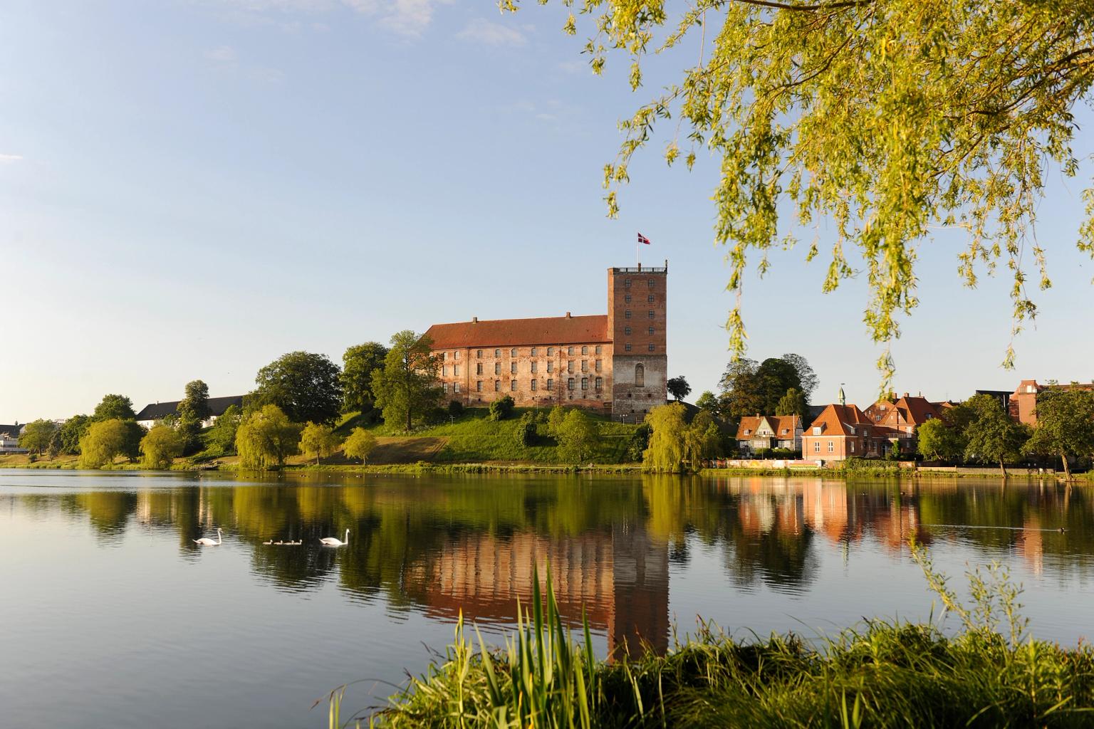 ett stort slott speglas i vattnet av en sjö