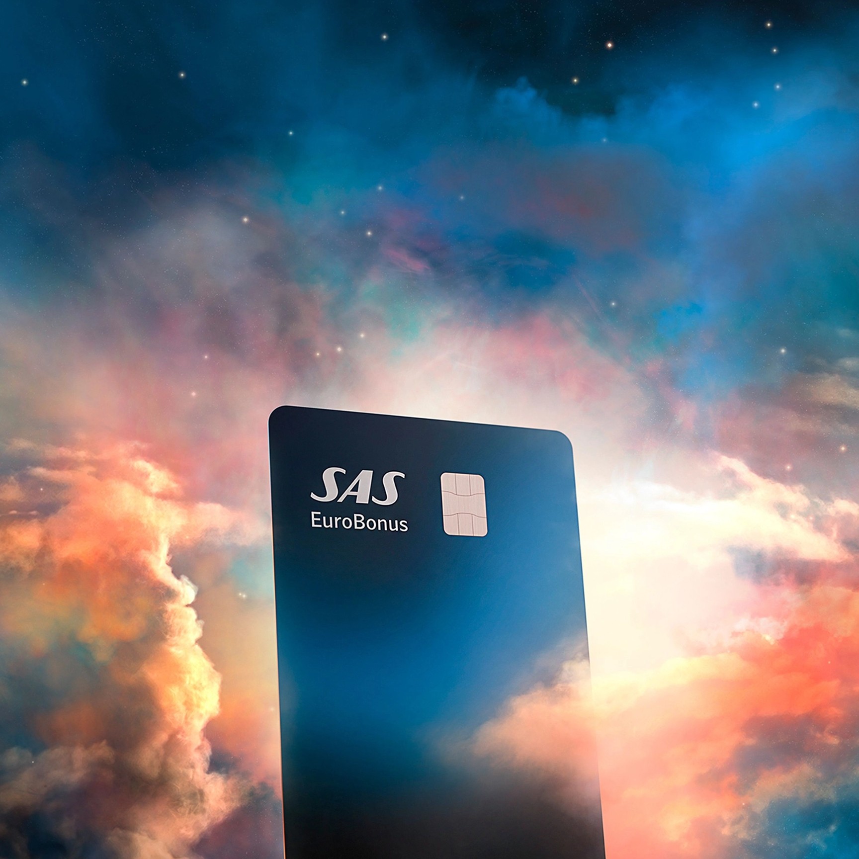 Et Lunar SAS EuroBonus Visa-kort, der svæver blandt farverige, drømmeagtige skyer under en stjerneklar nattehimmel.