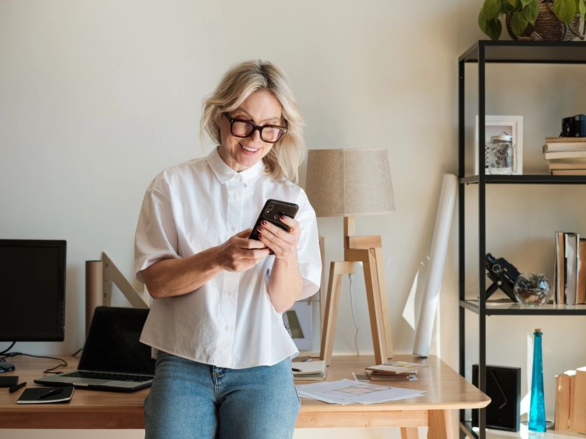 Woman checking phone older table