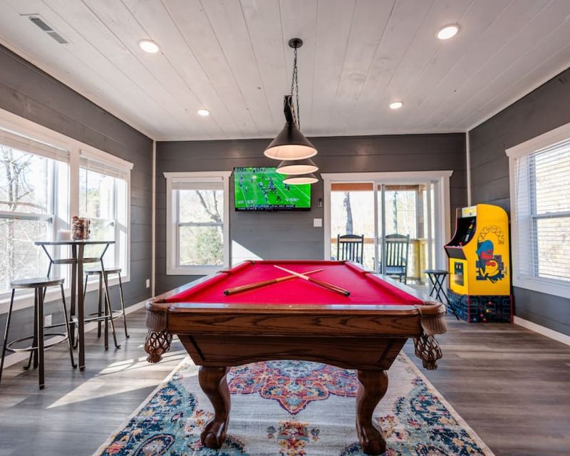 Gaming room including a pool table, two arcade games, and a large HDTV.