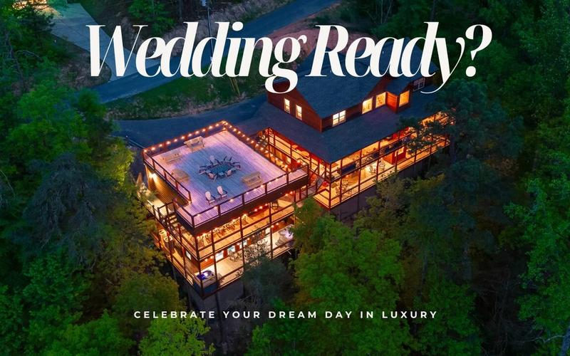 Aerial view of a large, well-lit cabin surrounded by trees at dusk with text overlay: Wedding Ready? Discover one of the top wedding venues and celebrate your dream day in luxury.