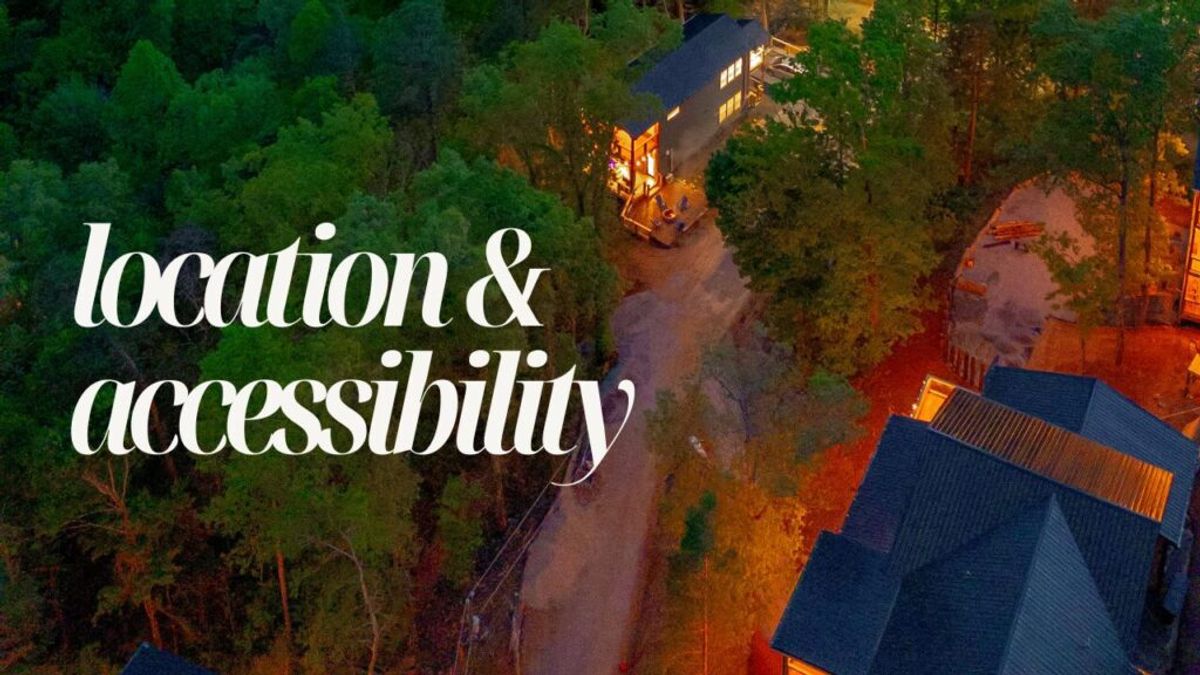 Aerial view of houses surrounded by trees at dusk, with a lit path between them. The words "location & accessibility" highlight what makes us stand out in large white text on the left side of the image.