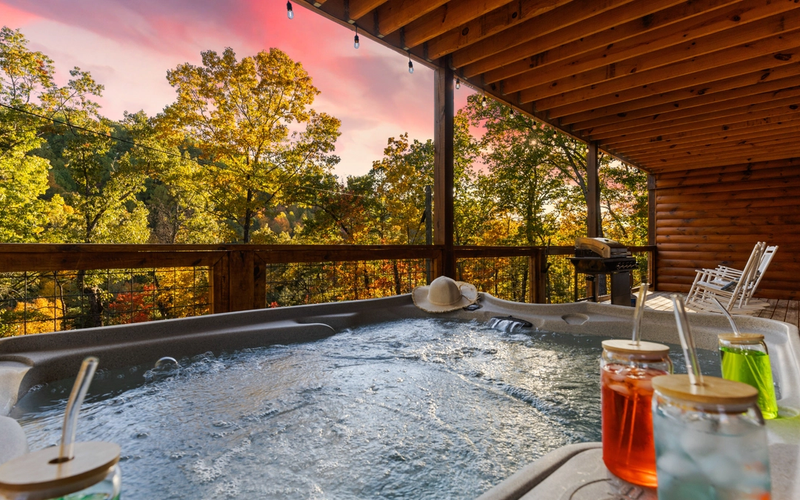 Private hot tub on a Gatlinburg cabin deck with scenic smoky mountain views at sunset