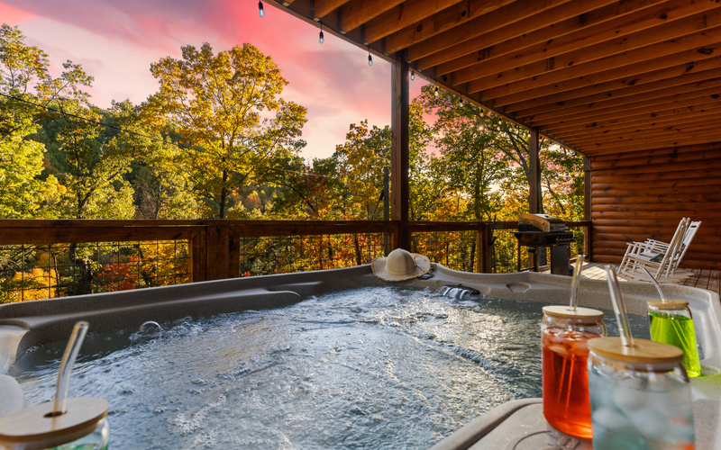 Private hot tub on a Gatlinburg cabin deck with scenic smoky mountain views at sunset